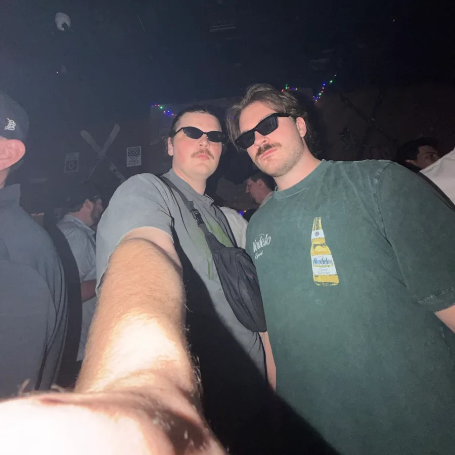 Jack and a friend in matching sunglasses and mustaches at a bar