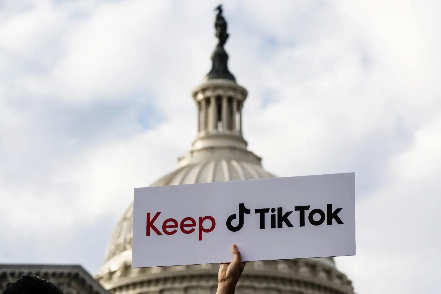 A Keep TikTok sign held up in front of the U.S. Capitol dome